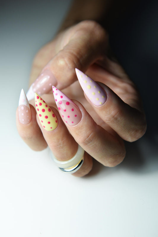 Pastel pink, yellow and white press-on nails with hand-painted polka dots