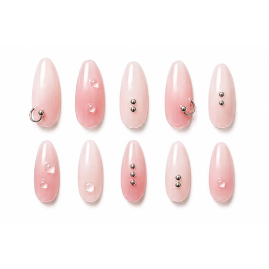 Milky pink press-on nails with silver rings, metallic beads and clear gel droplets