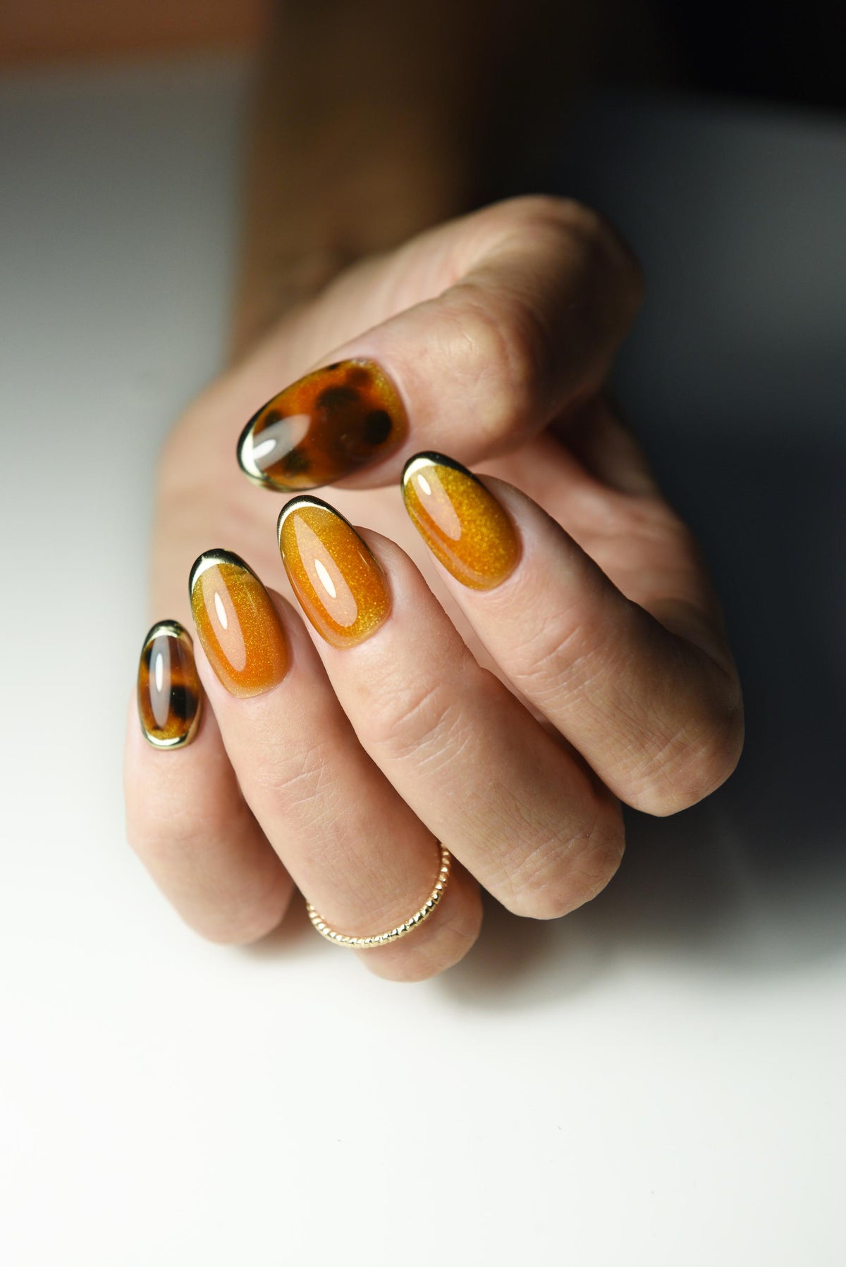 Burnt-orange cat-eye press-on nails with tortoise shell accents – detail view