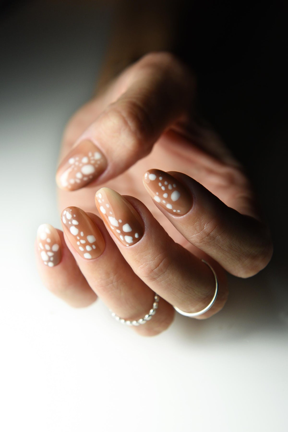 Caramel nude press-on nails with creamy white fawn spots – detail view