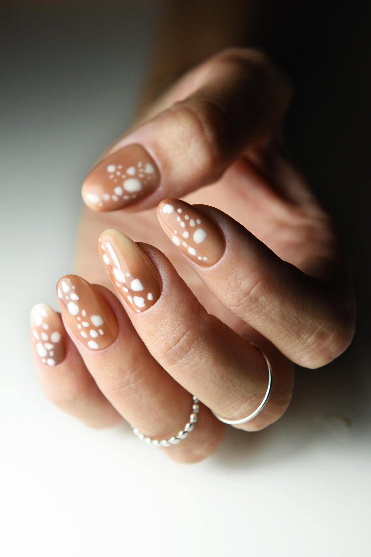 Caramel nude press-on nails with creamy white fawn spots – detail view