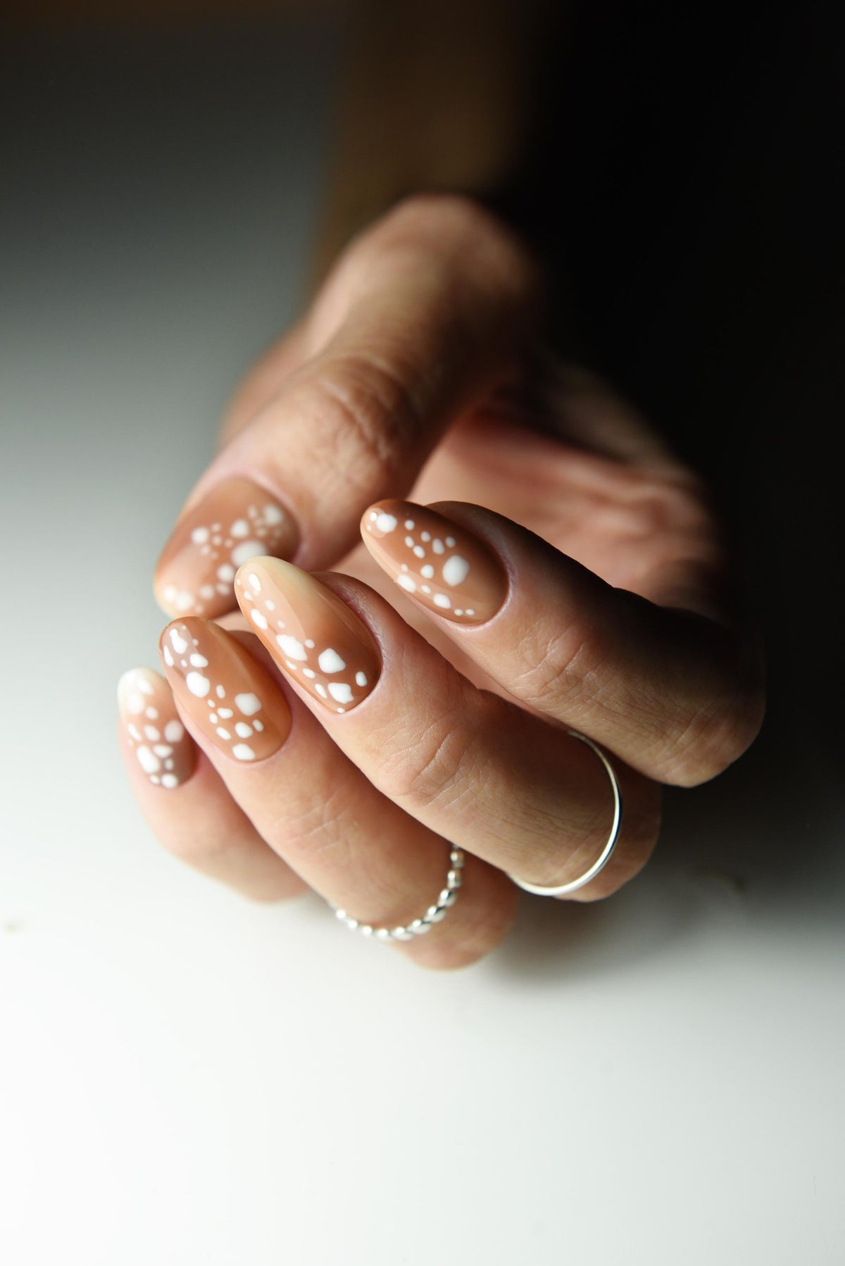 Caramel nude press-on nails with creamy white fawn spots – detail view