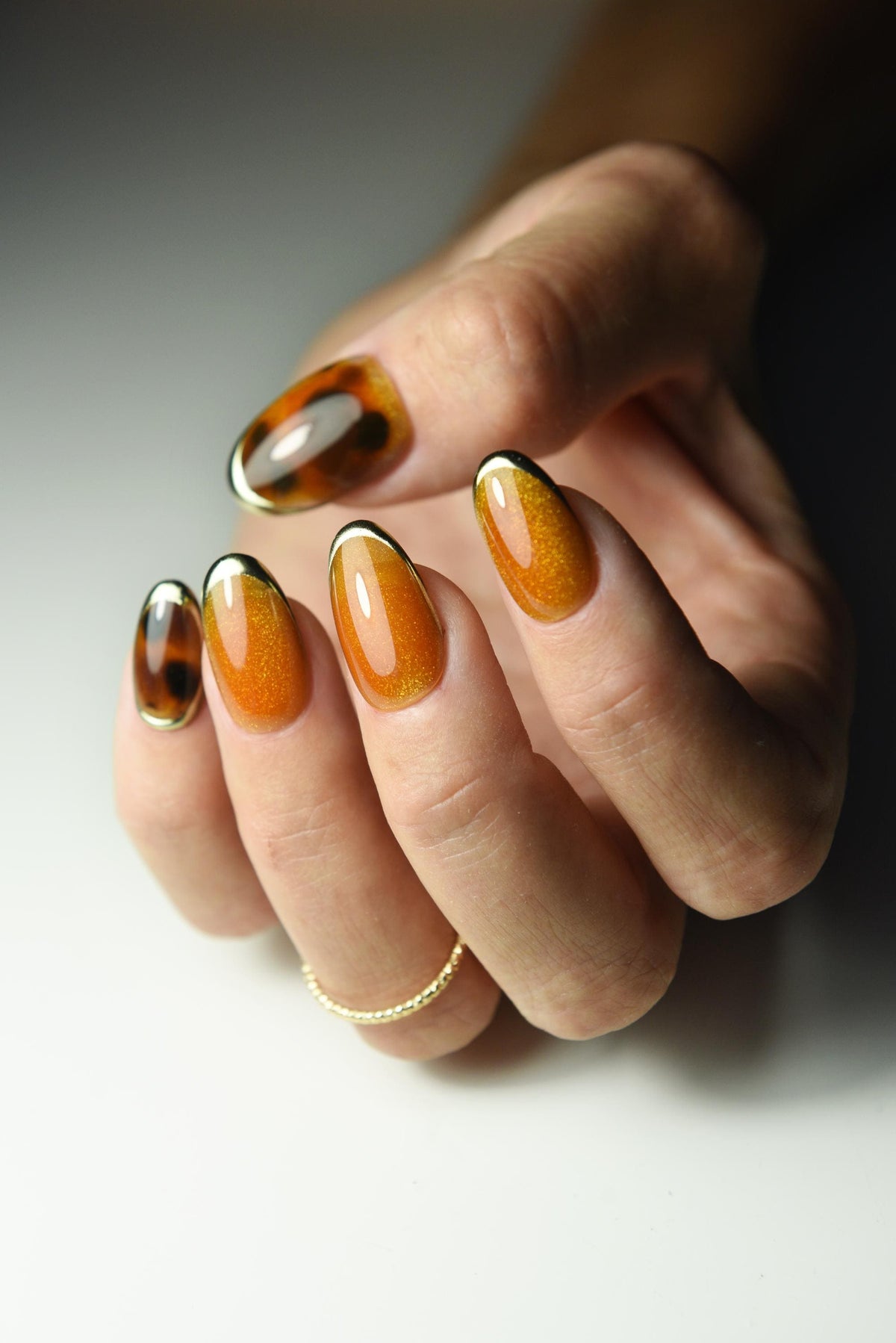 Burnt-orange cat-eye press-on nails with tortoise shell accents – detail view