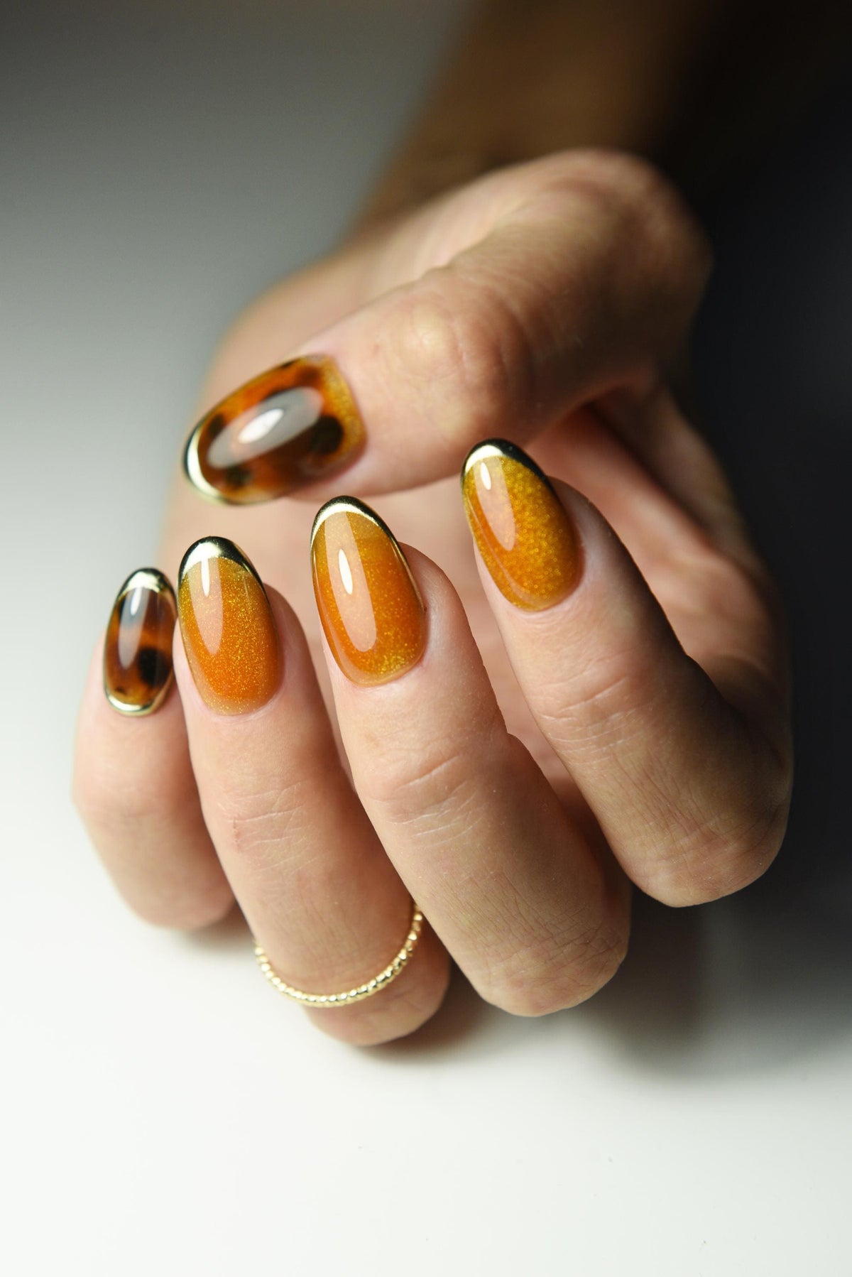 Burnt-orange cat-eye press-on nails with tortoise shell accents – detail view